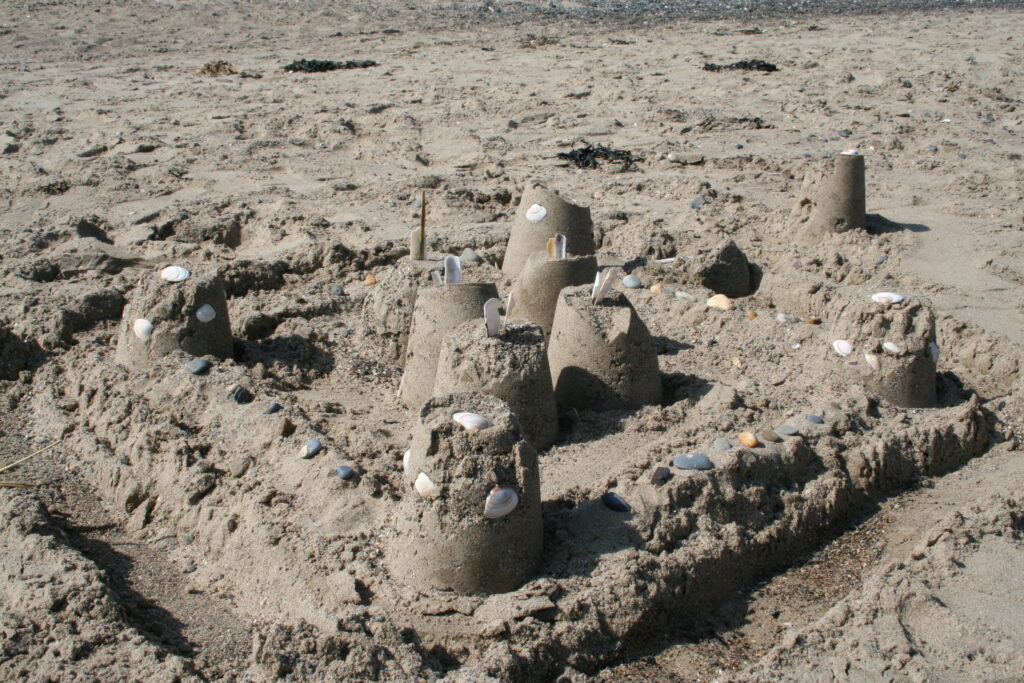A sandcastle decorated with shells.
