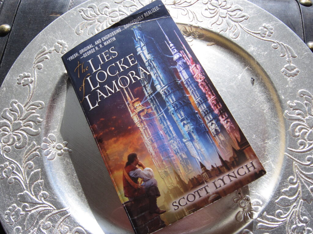 The book "The lies of Locke Lamora" on a silver coloursed plate.