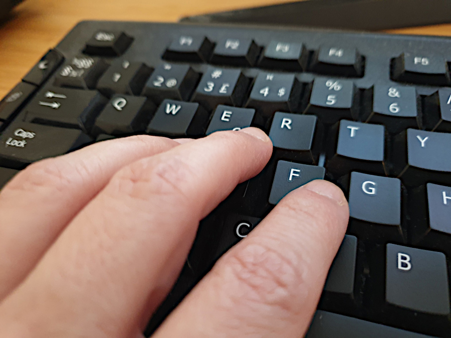 Fingers touching a black computer keyboard. Photo: Mittens and Sunglasses © 2021