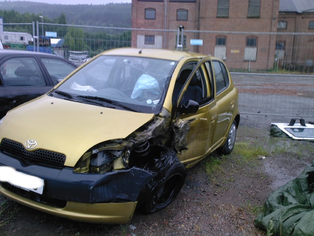 A golden coloured car, with a big chunch of the front ripped off.
