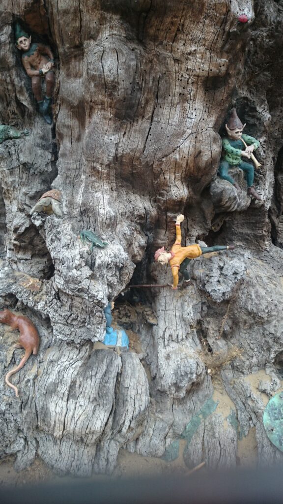 Small figurines of elves adn animals in the trunk of an old oak.