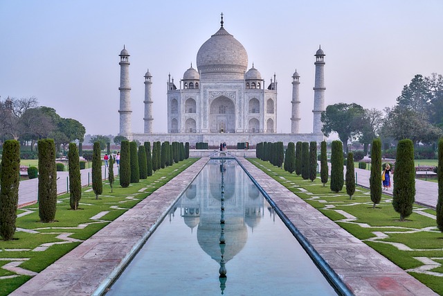 Photo of Taj Mahal, with a row of trees and a pool in front.